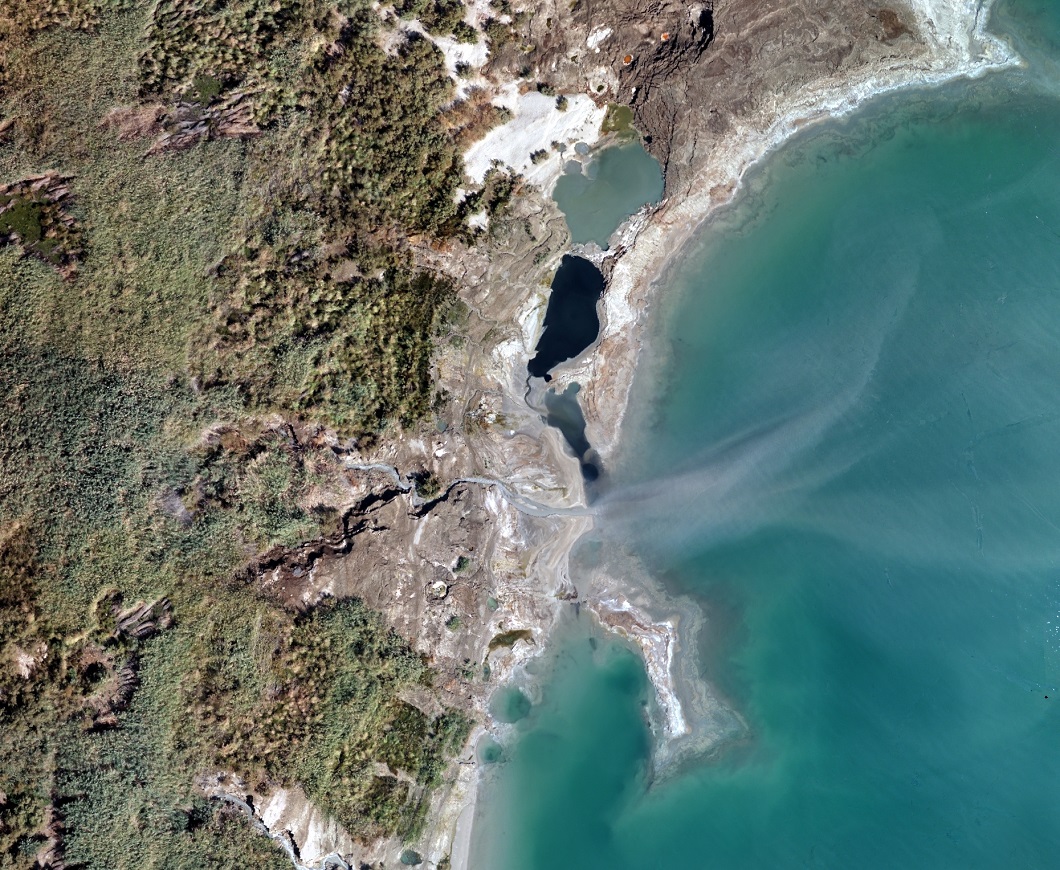 שמורת טבע עינות צוקים בתצלום מטיסן. בולטים בו הבולענים ליד קו החוף. צבע המים בהם נקבע על בסיס ריכוזים שונים של מינרלים- צילום טראסקאן מעבדות